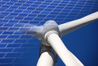 Close-up of wind turbine and solar panels representing renewable energy sources like wind and solar power for sustainable energy solutions.