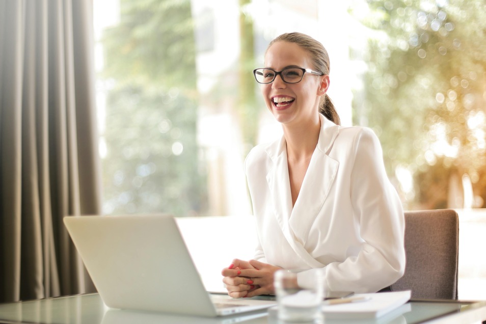 A manager in a business suit sitting behind a modern desk and laptop, demonstrating leadership.